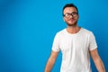 Portrait of smiling handsome guy in white t-shirt over blue background Royalty Free Stock Photo