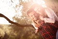 Portrait of smiling handsome man giving piggy back to his girlfriend in the nature Royalty Free Stock Photo