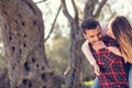 Portrait of smiling handsome man giving piggy back to his girlfriend in the nature Royalty Free Stock Photo