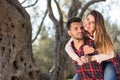 Portrait of smiling handsome man giving piggy back to his girlfriend in the nature Royalty Free Stock Photo