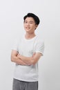 Portrait of smiling handsome man in white t-shirt  standing with crossed arms isolated on gray background Royalty Free Stock Photo