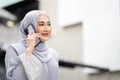 Portrait of smiling happy beautiful muslim woman relaxing using digital smartphone in the city Royalty Free Stock Photo