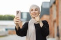 Portrait of smiling happy beautiful muslim woman relaxing using digital smartphone. Royalty Free Stock Photo