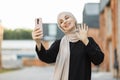 Portrait of smiling happy beautiful muslim woman relaxing using digital smartphone. Royalty Free Stock Photo