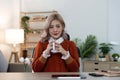 Portrait of smiling happy cheerful beautiful pretty asian woman relaxing drinking and looking at cup of hot coffee or Royalty Free Stock Photo