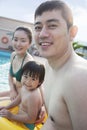 Portrait of smiling happy family sitting by the pool Royalty Free Stock Photo