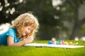 Portrait of smiling happy kid enjoying art and craft drawing in backyard or spring park. Happy child playing outside Royalty Free Stock Photo