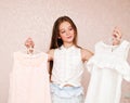 Portrait of smiling happy little girl child schoolgirl choosing dresses clothes