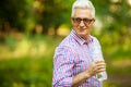 Portrait of a smiling happy mature old man drinking water Royalty Free Stock Photo