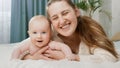 Portrait of smiling happy mother embracing her little baby boy in bed at morning. Concept of parenting ,baby care and Royalty Free Stock Photo