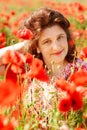 Portrait smiling happy old Elderly woman having fun, walking in a field with poppy flowers. Healthcare lifestyle senior lady relax Royalty Free Stock Photo