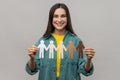 Happy woman holding in hands chain of multicultural paper people, multinational race unity concept. Royalty Free Stock Photo