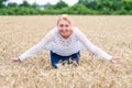 Portrait of a smiling happy woman in a ripe wheat field.