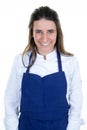 Portrait of smiling happy young woman chef on background with blue apron Royalty Free Stock Photo