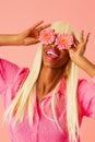 Smiling happy young woman holding two gerbera flowers over her eyes Royalty Free Stock Photo