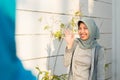 Portrait of A smiling hijab woman welcomed her friend in front of her house door