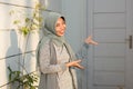 Portrait of A smiling hijab woman welcomed her friend in front of her house door