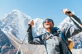 Portrait of smiling Hiker man on Taboche 6495m and Cholatse 6440m peaks background with trekking poles, UV protecting sunglasses.