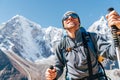 Portrait of smiling Hiker man on Taboche 6495m and Cholatse 6440m peaks background with trekking poles, UV protecting sunglasses. Royalty Free Stock Photo
