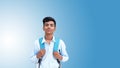 Portrait of happy indian teenager college or school boy with backpack, isolated on lite blue background. Smiling young asian male Royalty Free Stock Photo