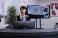 Portrait of smiling hospital receptionist working at front desk using telephone talking with patient Royalty Free Stock Photo