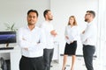 Portrait of smiling indian businessman standing in modern office on colleagues background Royalty Free Stock Photo