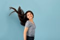 Portrait of smiling Indian teenage girl posing with long dark flying hair on blue studio background Royalty Free Stock Photo