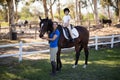 Portrait of smiling jockey and girl with horse Royalty Free Stock Photo