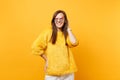 Portrait of smiling joyful young woman in fur sweater, heart glasses putting hand on head isolated on bright yellow Royalty Free Stock Photo