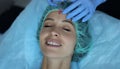 Smiling lady gets injection of botox in her forehead, cosmetologist using syringe with liquid Royalty Free Stock Photo