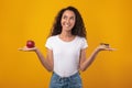 Portrait of Smiling Latin Lady Holding Apple And Donut Royalty Free Stock Photo