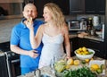Portrait of smiling laughing white Caucasian couple two people pregnant woman with husband cooking food, eating citrus Royalty Free Stock Photo