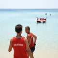 Portrait of smiling lifeguards against beautiful sea on a sunny day. Salento, Apulia, Italy