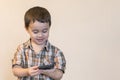 Portrait of a smiling little boy holding mobile phone isolated over light background. cute kid playing games on smartphone. copy Royalty Free Stock Photo