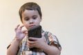 Portrait of a smiling little boy holding mobile phone isolated over light background. cute kid playing games on Royalty Free Stock Photo