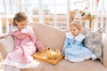 Portrait of smiling little children sisters in beautiful dress sitting posing with little yellow ducklings in summer Royalty Free Stock Photo