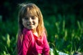 Portrait of a smiling little cute girl lying on green green grass. Royalty Free Stock Photo