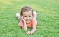 Portrait of a smiling little girl lying on green grass Royalty Free Stock Photo