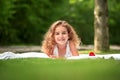 Portrait of a smiling little girl lying on green grass Royalty Free Stock Photo