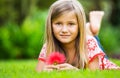 Portrait of a smiling little girl lying on green grass Royalty Free Stock Photo