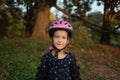 Portrait of a smiling little girl - roller skater in a helmet and elbow pads.