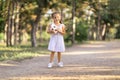 Portrait of a smiling little girl with a soccer ball in her hands. In the park on the road. Royalty Free Stock Photo