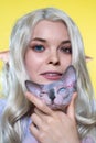 Portrait of smiling, looking at camera young blonde woman cosplay elf, holding Sphinx kitten Royalty Free Stock Photo