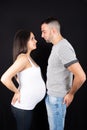 Portrait of smiling loving couple hugging face to face while standing isolated over black background Royalty Free Stock Photo