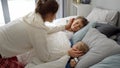 Portrait of smiling loving mother covering with blanket and looking at her children sleeping in bed. Concept of family happiness, Royalty Free Stock Photo