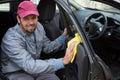 Male auto service staff cleaning car door Royalty Free Stock Photo