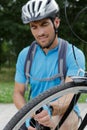 portrait smiling male cyclist repairing bike