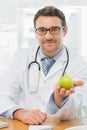 Portrait of a smiling male doctor holding an apple Royalty Free Stock Photo