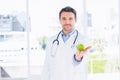 Portrait of a smiling male doctor holding an apple Royalty Free Stock Photo