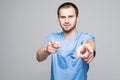 Portrait of a smiling male doctor pointing finger on you solated on a white background Royalty Free Stock Photo